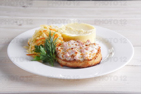 Fish cutlet with ham and melted cheese topping served with pickled cabbage and mashed potato