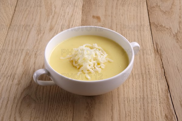 Soup puree with cheese and mushrooms on wooden table