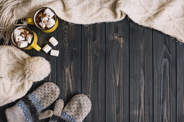 Mugs with marshmallows near warm wear