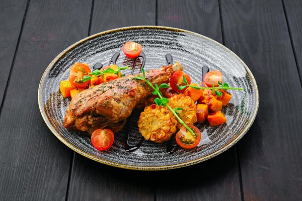 Roaster turkey leg with fried pumpkin and grilled corn decorated with tomato