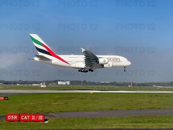 Large aircraft for intercontinental flights jet passenger aircraft jet Emirates Airbus A380-800 A6-EEH on approach just in front of touch down landing touchdown on runway of Duesseldorf International ...