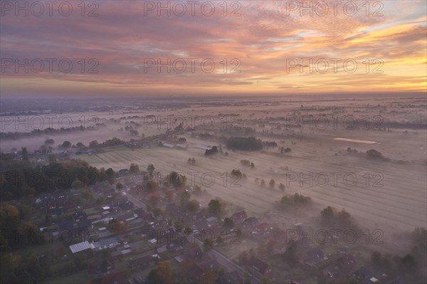 Aerial view of the landscape near Fuenfhausen in Hamburg's Kirchwerder district in autumnal morning atmosphere with light ground fog. In the background the nature reserve Kirchwerder Wiesen. Fuenfhaus...