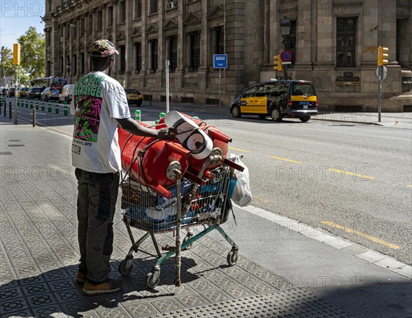Man collects small metal in shopping trolley