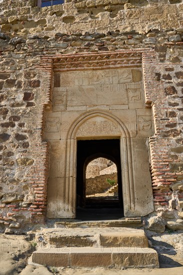 Entrance portal with old Georgian inscription and relief panels with animal motifs