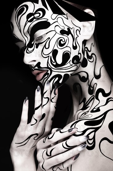 Beautiful girl with art black and white makeup and nails. Creative beauty face. Photo taken in the studio