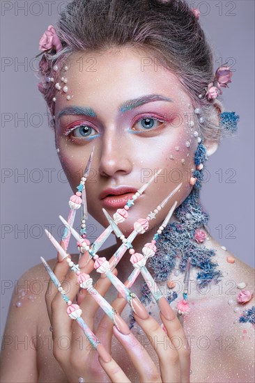 Beautiful girl in the image of a sweet fairy with art make-up and with long design nails. Creative manicure. Photo taken in the studio