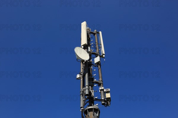 Transmission mast with directional radio antenna and antennas for mobile phone reception