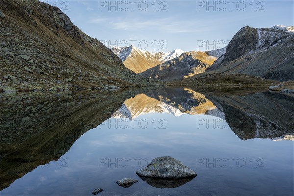 Slightly snow-covered mountains reflected in Schwarzsee in autumn on the Flueela Pass