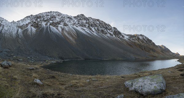 Lightly snow-covered mountains at Schottensee in autumn at the Flueela Pass