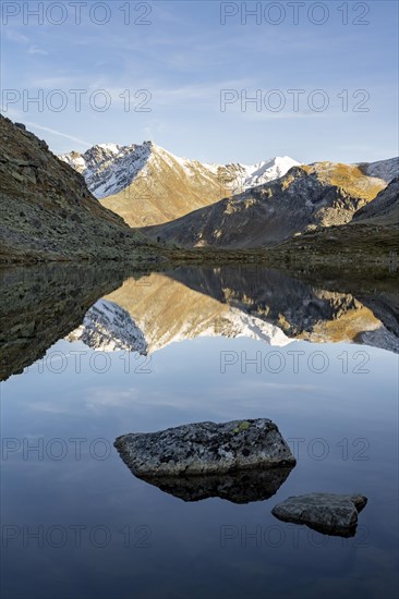 Slightly snow-covered mountains reflected in Schwarzsee in autumn on the Flueela Pass