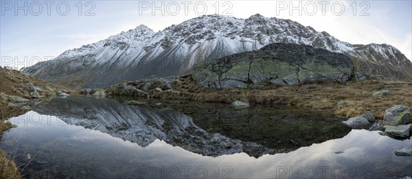 Lightly snow-covered mountains and mountain lake in autumn on the Flueela Pass