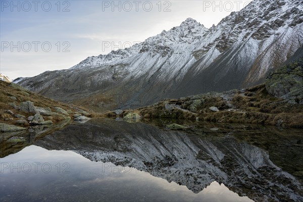 Lightly snow-covered mountains and mountain lake in autumn on the Flueela Pass