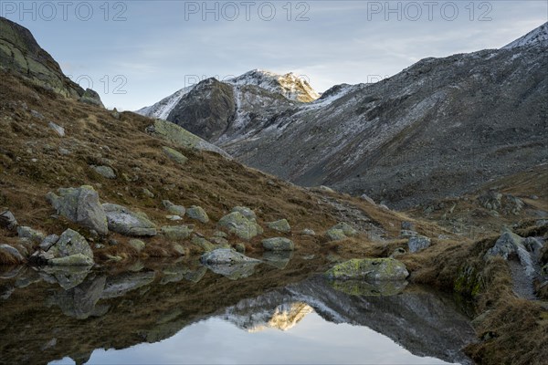 Lightly snow-covered mountains and mountain lake in autumn on the Flueela Pass