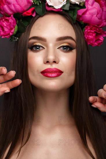 Beautiful girl with bright make up and flowers on her head. Beauty face. Photos shot in studio