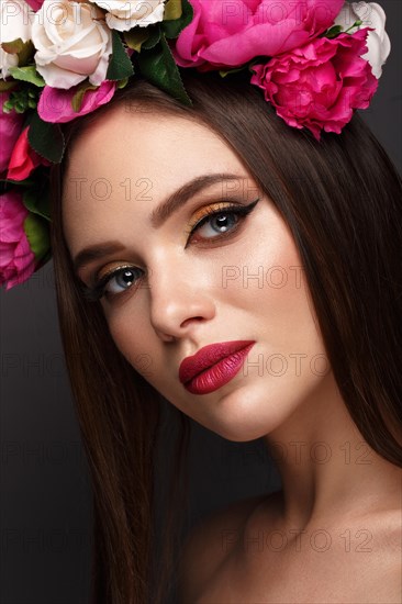 Beautiful girl with bright make up and flowers on her head. Beauty face. Photos shot in studio