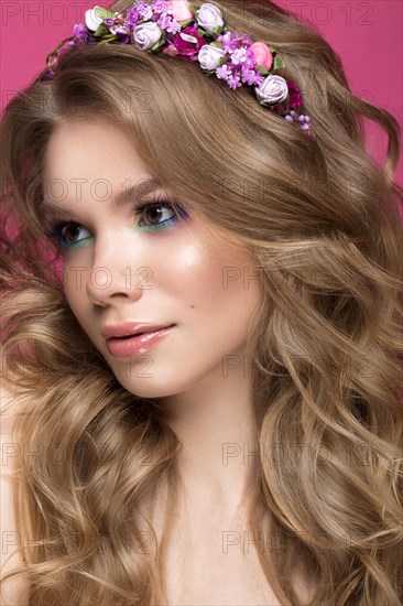 Portrait of a beautiful blond girl in image of the bride with purple flowers on her head. Beauty face. Photo shot in the Studio