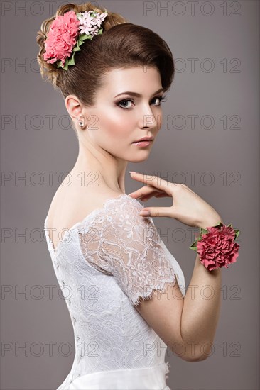 Portrait of a beautiful woman in the image of the bride with flowers in her hair. Picture taken in the studio on a black background