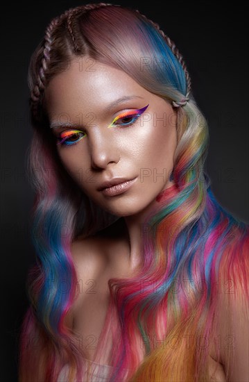 Beautiful girl with multi-colored hair and creative make-up and hairstyle. Beauty face. Photo taken in the studio