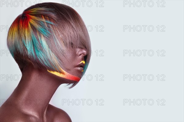 Beautiful girl with multi-colored hair and creative make up and hairstyle. Beauty face. Photo taken in the studio