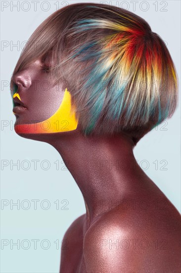 Beautiful girl with multi-colored hair and creative make up and hairstyle. Beauty face. Photo taken in the studio