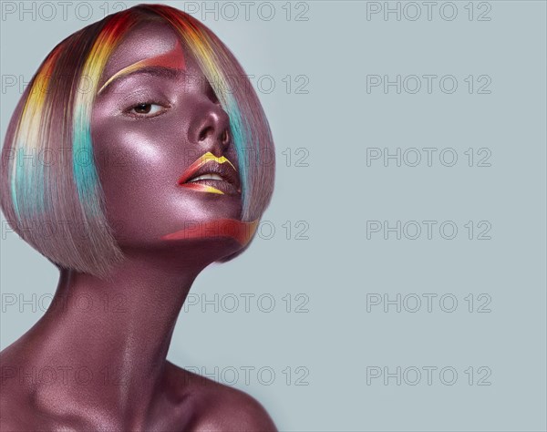 Beautiful girl with multi-colored hair and creative make up and hairstyle. Beauty face. Photo taken in the studio