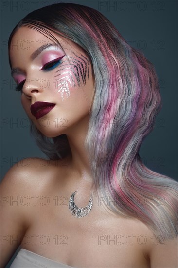 Beautiful girl with multi-colored hair and creative make up and hairstyle. Beauty face. Photo taken in the studio