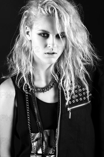 Daring girl model in black leather dress in the style of rock