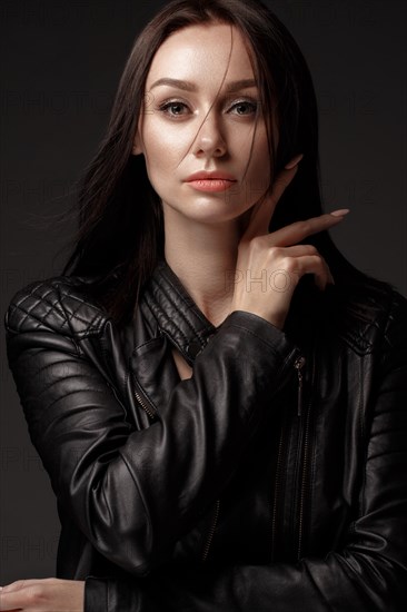 Daring girl model in black leather dress