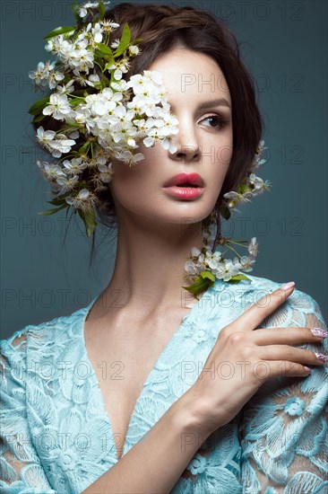 Beautiful brunette girl in blue dress with a gentle romantic make-up