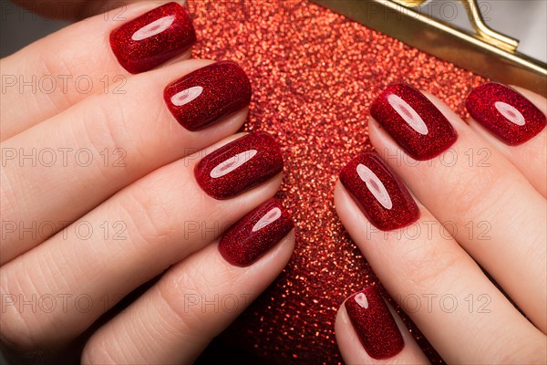 Bright festive red manicure on female hands. Nails design