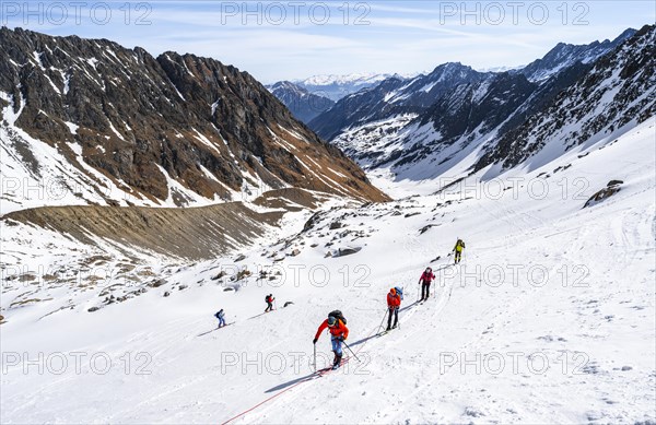 Group of ski tourers walking on the rope on the glacier