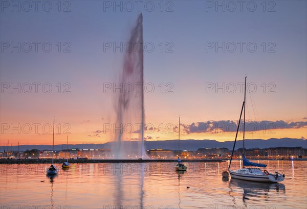 The Jet d'eau at dusk is the landmark in Geneva's harbour basin