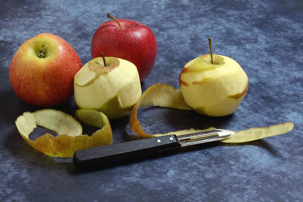 Peeled apples with peeling knife