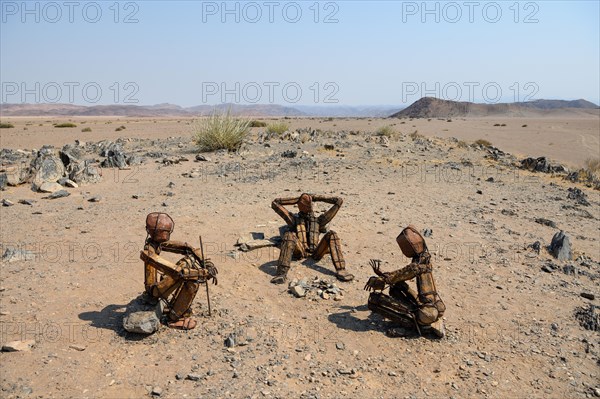 Three stone men by the artist RENN at a fireplace