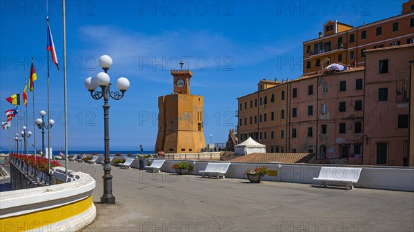 Lighthouse next to houses in pastel-coloured facades