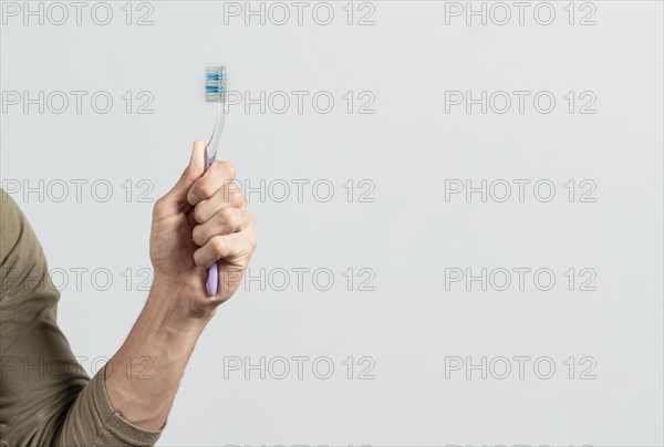 Hand holding toothbrush isolated on white. Male hand showing a toothbrush isolated. Toothbrush concept