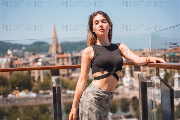 Portrait of a young model in a viewpoint of the city from the heights