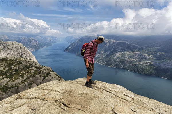 Hiker standing carefully at the rocky outcrop
