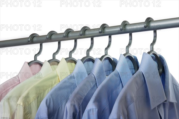 Business shirts hanging on a clothing rail and cut out on a white background