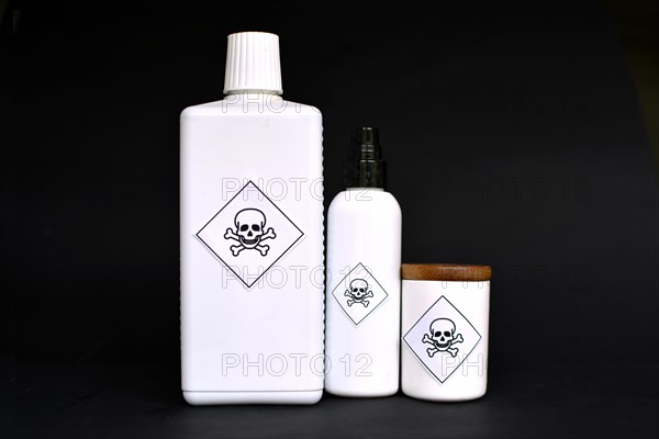 Different shaped white containers with poison labels on black background