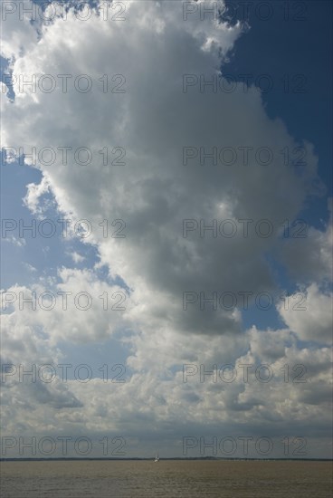 Small yacht under a large cloud
