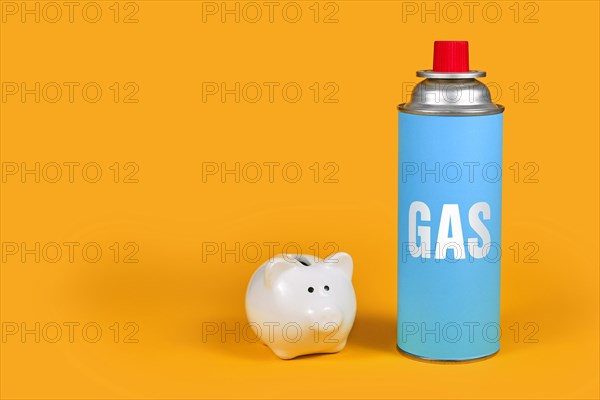 Gas cartridge bottle with piggy bank on yellow background