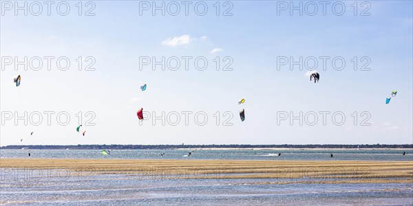 Group of kitesurfers kitesurfing in the Bay of Arcachon