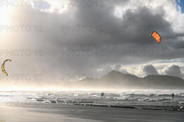 Kitesurfers at sunset on the beach of Caleta de Famara