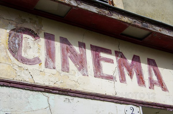 Faded old French lettering Cinema on a house facade in France