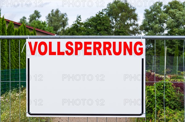 A rectangular board with a lot of free text space with the word FULL EXCLUSION on a construction fence