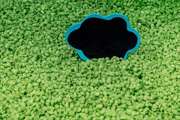 Speech bubble placed on green color sand