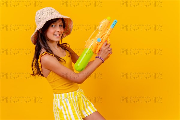 Portrait of a girl with a water pistol on summer vacation