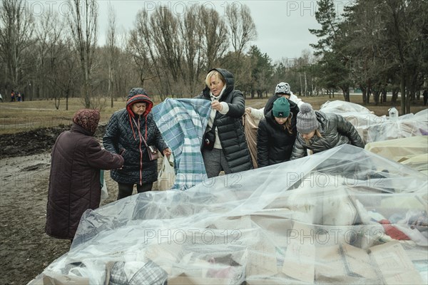 Residents of the house destroyed by a Russian missile attack that killed 45 people receive relief goods from neighbourhood donations