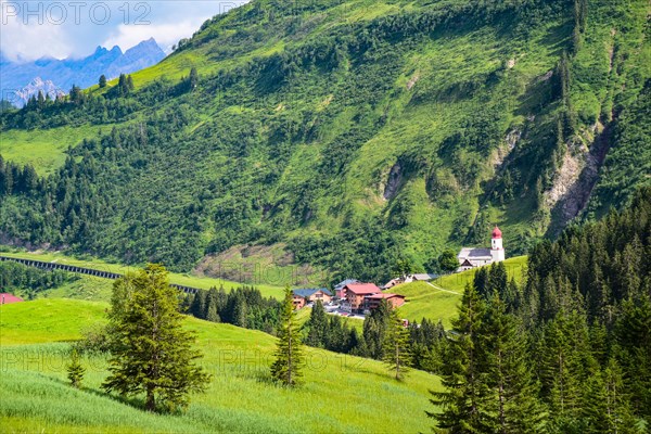 View of Damuels and the village church of Sankt Nikolaus in the Bregenzerwald in the background the Rote Wand